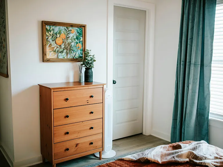 Plenty of dresser space, cozy layers, and calming decor make this bedroom easy to relax in.