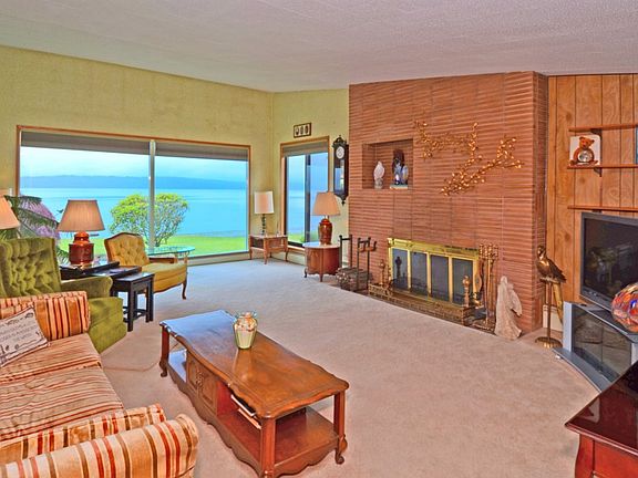 Spacious living room with fireplace has large windows to enjoy the breathtaking view.