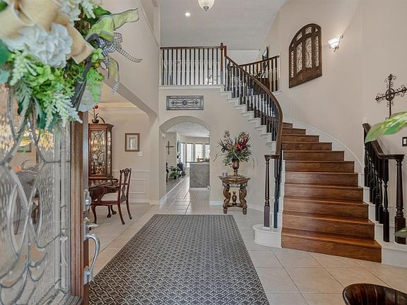 Impressive entry through leaded glass door into a 2 story foyer, tiled flooring and spiral staircase.