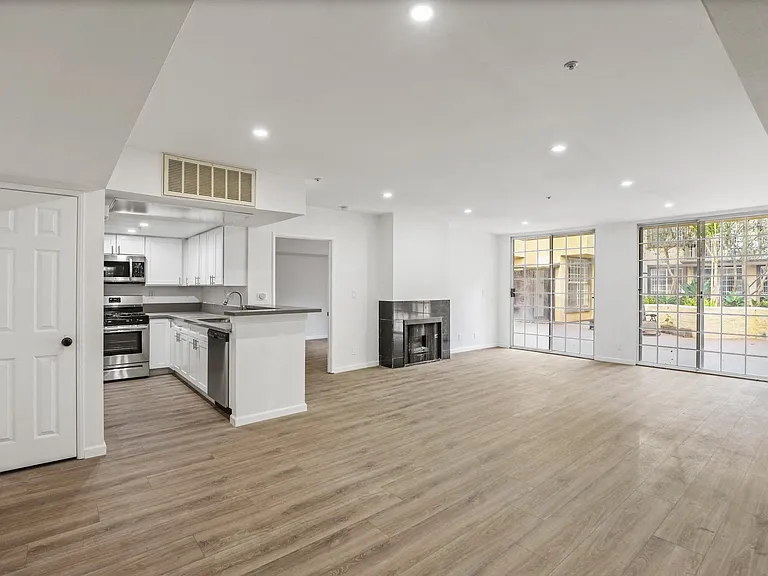 Open-Concept Floor Plan with Electric Fireplace, Recessed Lighting, Vinyl Flooring, and Lots of Windows with Natural Light