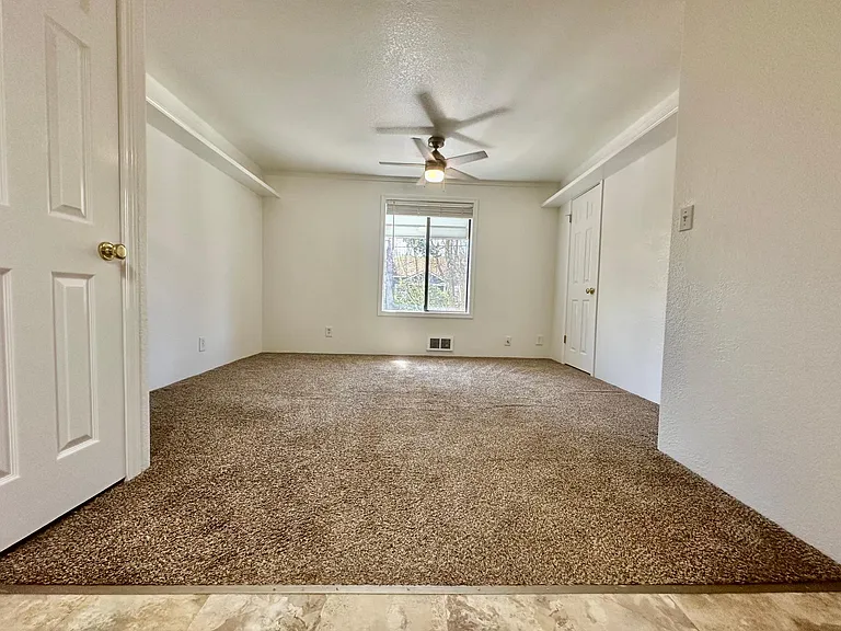 Living area of the apartment and window overlooking the tree-lined street below. NEW FLOORING COMING SOON! STAY TUNED FOR NEW PHOTOS!