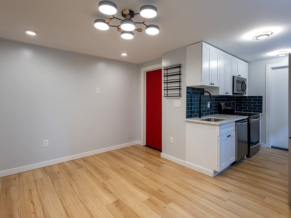 Living space, red bathroom door, full kitchen