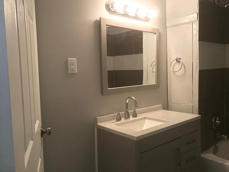 Large bathroom with tub and tiled shower.