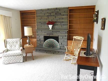 Living room with stone fireplace and built in shelves