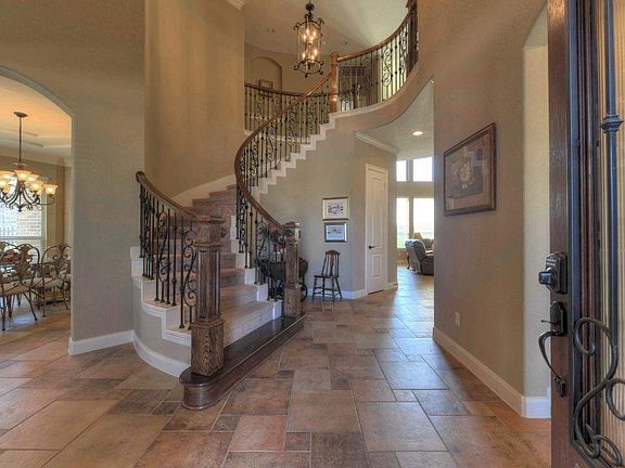 Grand entrance with 20' ceilings, wrought iron stairs, and open floor plan!