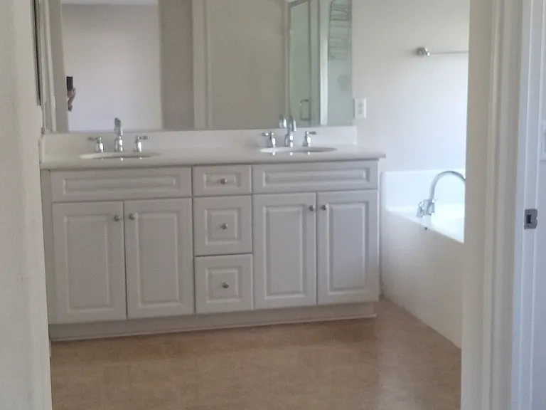 master bedroom with two sinks and walk in closet.