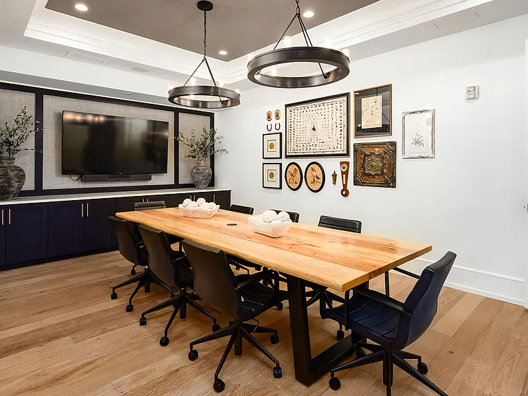 Conference Room with Wall-Mounted TV, Art Gallery, and Natural Wood Table