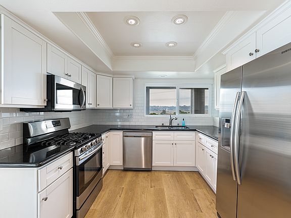 renovated kitchen with granite counters, stainless steel appliances and tile backsplash