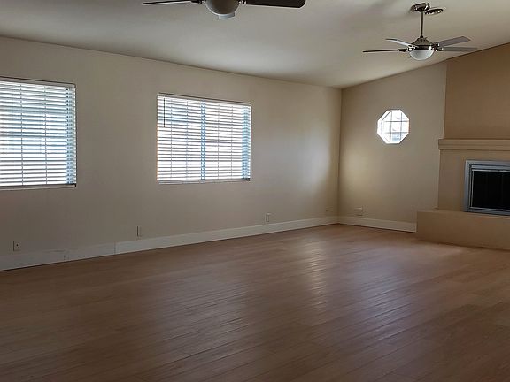 Great Room 2: Shows floor to ceiling stucco fireplace with wood burning insert and glass doors.