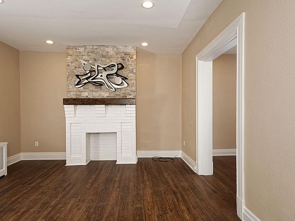 Smart looking Living Room with Recesed Lights, New Flooring, Decorative Fireplace, Stone Decoration, and Abstract Sculpture!