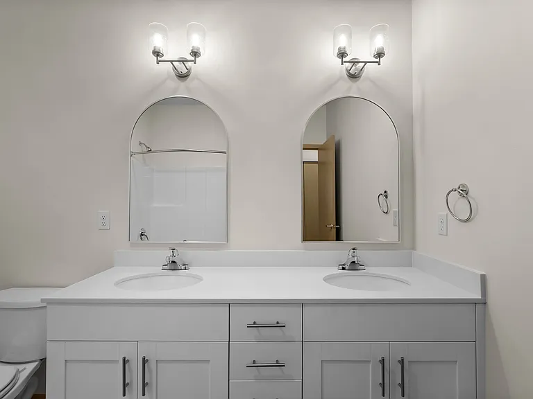 Elegant dual vanity with stylish arched mirrors. Elegant dual vanity with stylish arched mirrors.