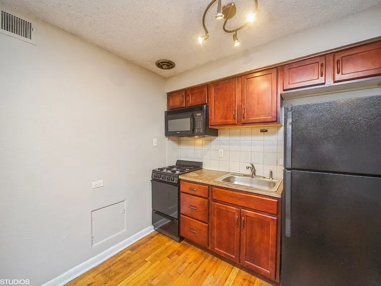 Kitchen with all black appliances and a built-in microwave