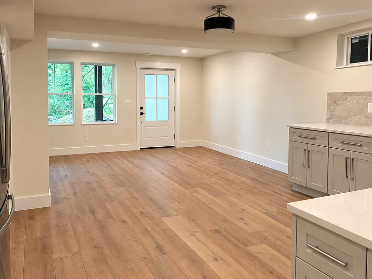 The large garden-level living room is filled with natural light and flows seamlessly into the eat-in kitchen, creating an open and inviting space for relaxing and entertaining.