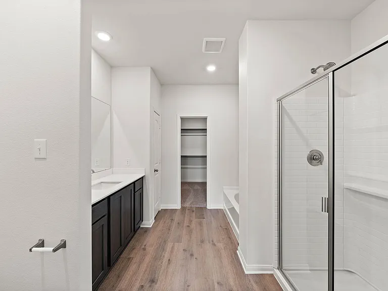 The master bathroom has a large walk-in, glass shower and a garden tub.