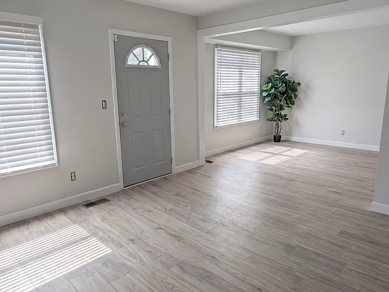 Standing over by the TV showing the spaciousness, flow, and openness of the living room to dining area that is right off of the kitchen