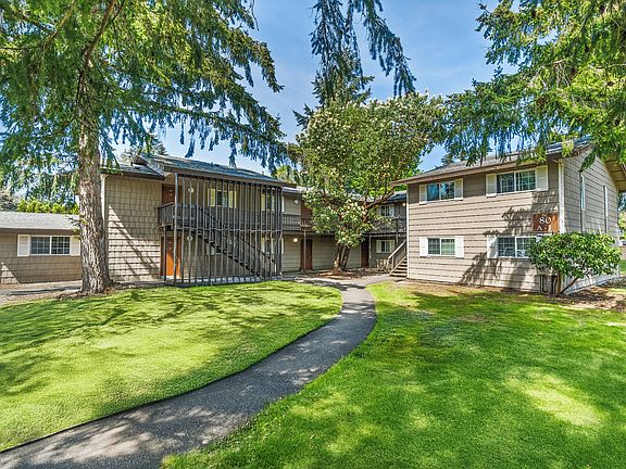 Picturesque view of a two-story apartment building surrounded by lush greenery.