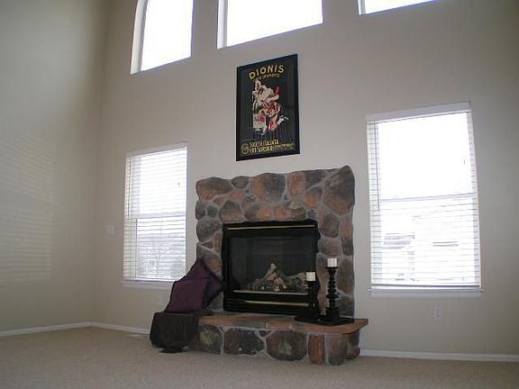 Two story family room with stone faced gas fireplace.