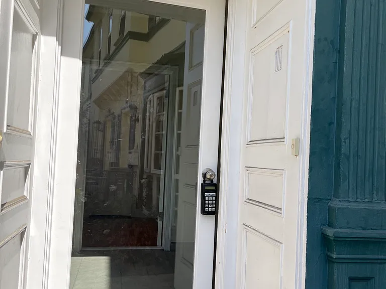 SECURITY DOOR LEADS TO HALLWAY AND DOWNSTAIRS UNIT