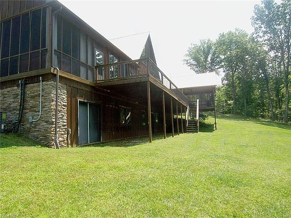 Partial rear view showing screened hot tub area off Master Suite, deck and additional screened porch for dining