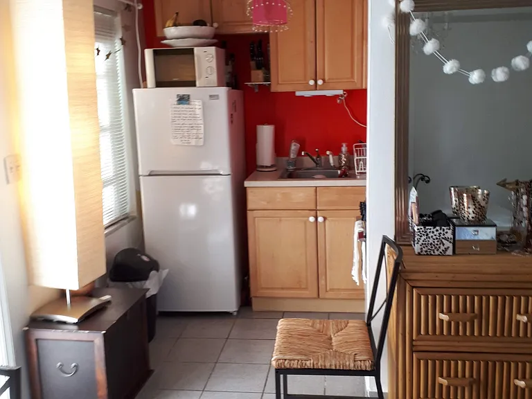 Bright and clean Kitchen with microwave, stove and oven, sink. Cupboard