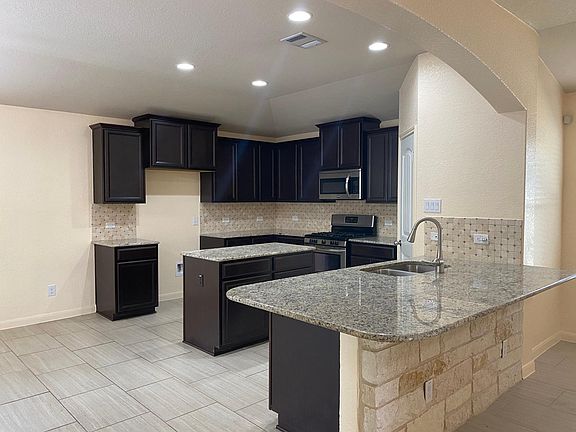 Kitchen with granite counters, large pantry and stainless appliances. New Refrigerator included.