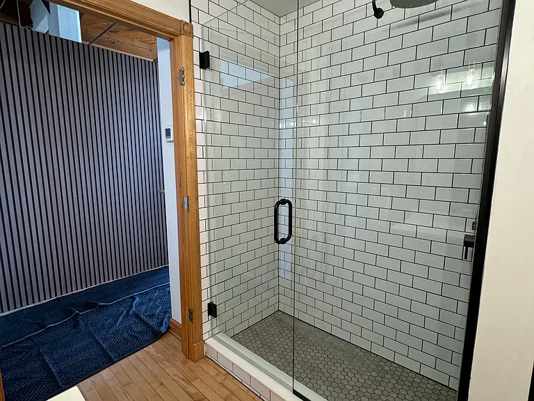 Rainfall shower head, hand wand, and floor to ceiling tile. Dark grout for EASY cleaning