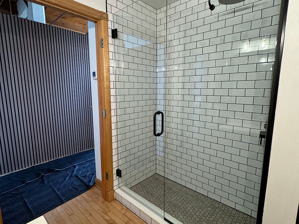 Rainfall shower head, hand wand, and floor to ceiling tile. Dark grout for EASY cleaning