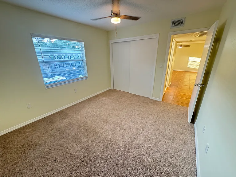 The guest bedroom offers a comfortable space, featuring a new ceiling fan that enhances air circulation and comfort. The room is fitted with new 2-inch window blinds.