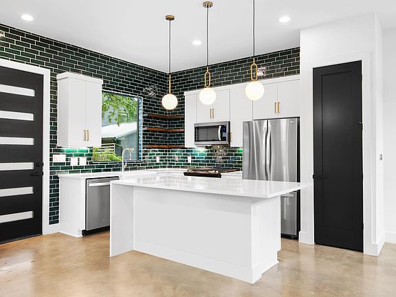 Sleek emerald tile and modern lighting / brand new appliances
