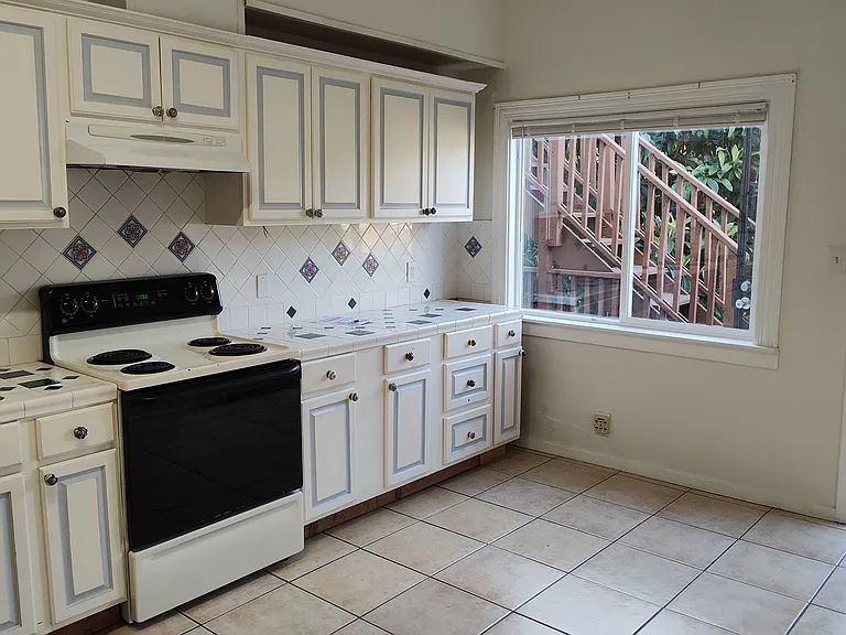 kitchen and back patio doorway, standing in front of refrigerator and hallway to bedrooms