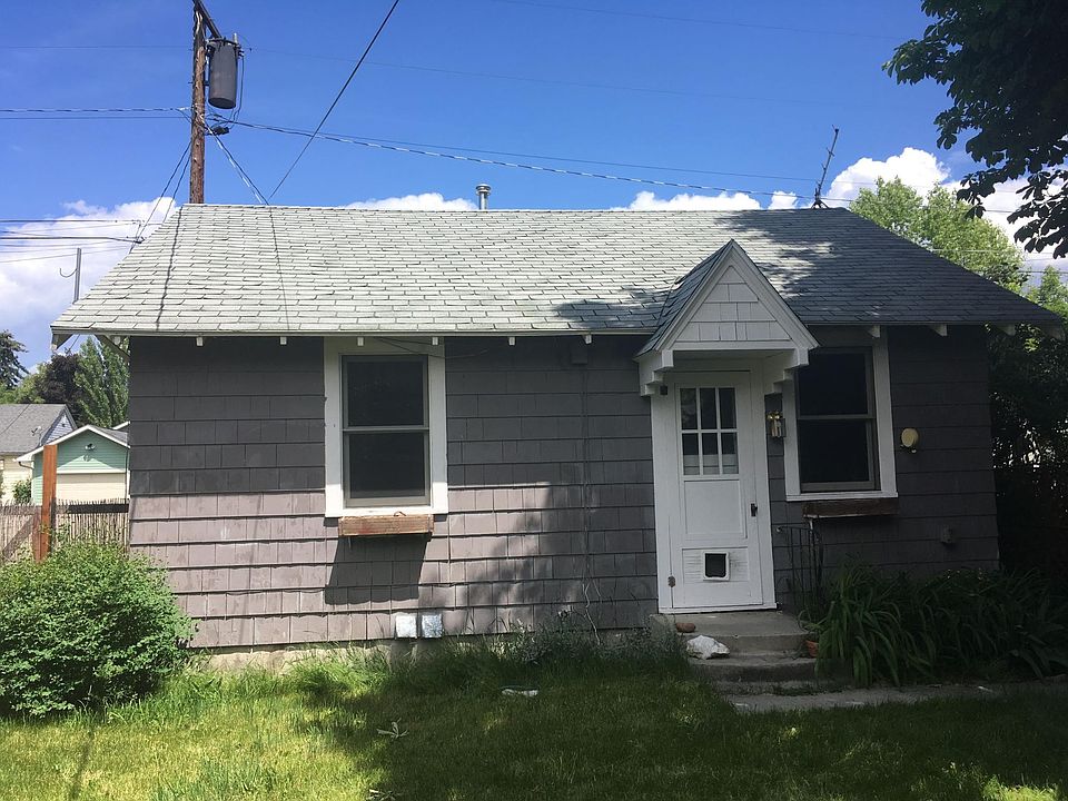 View of cottage from shared yard. Window boxes outside first bedroom (on left) and living room (on right).