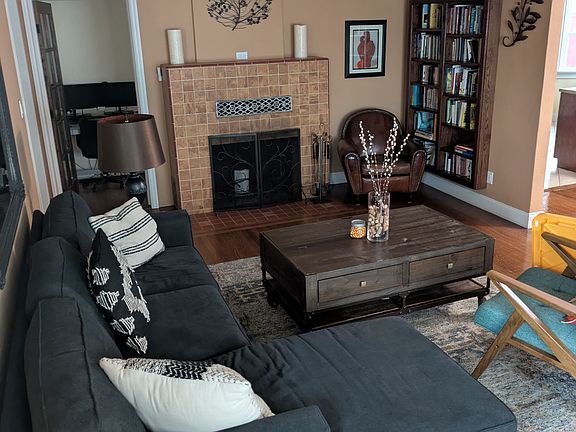 Living room has a working wood burning fireplace and built-in bookshelf. Gorgeous Stained Glass Ceiling Fan.