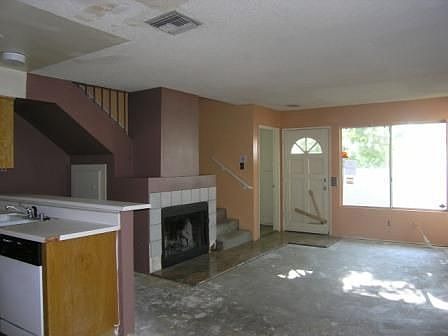 Living room offers under stair storage, 1/2 bath and granite floor accents