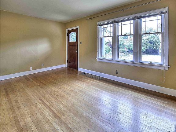 Living room offers leaded glass windows and hardwood floor. 