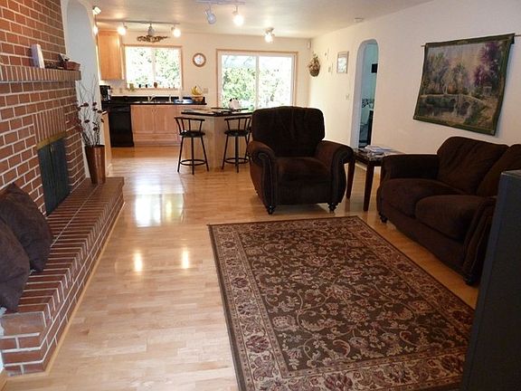 Off the entry is the family room with a brick fireplace & hardwood floor that leads to the kitchen a