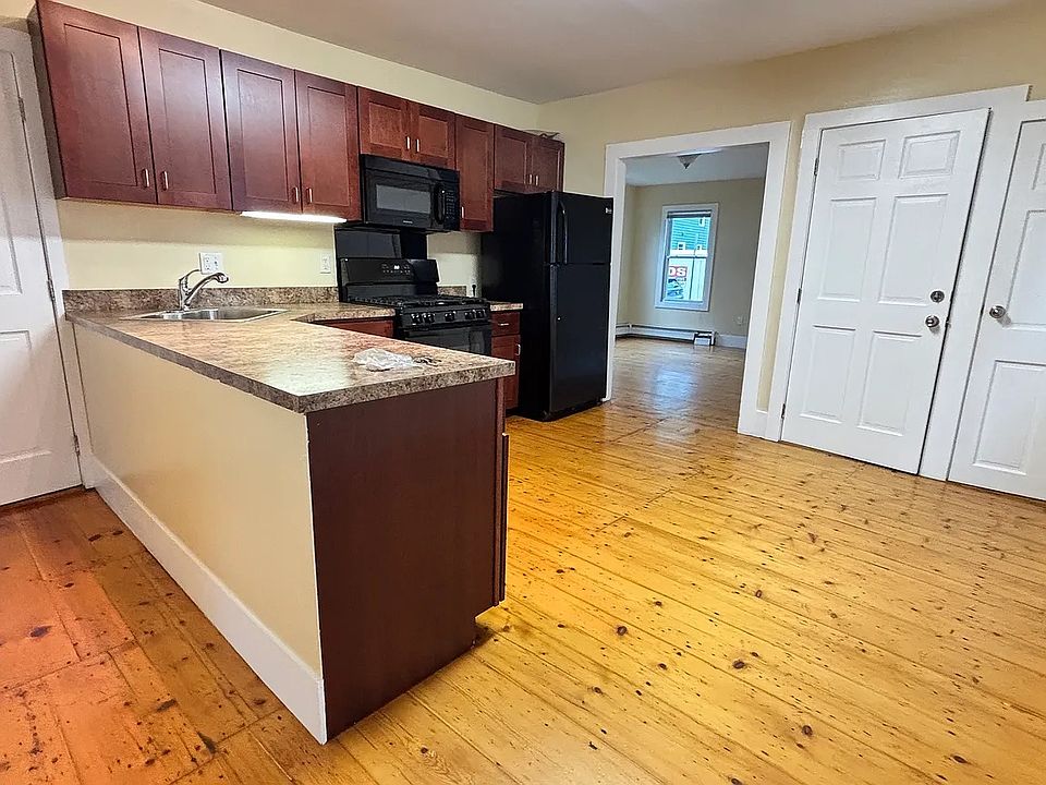 Kitchen, showing front door to unit, pantry door, doorway to living room and bathroom door