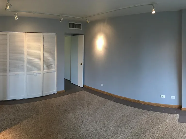 Bedroom looking back toward closet and door to bathroom and more additional closets/storage.
