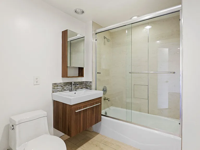 Bathroom withe Full-Size Bathtub with Glass Doors