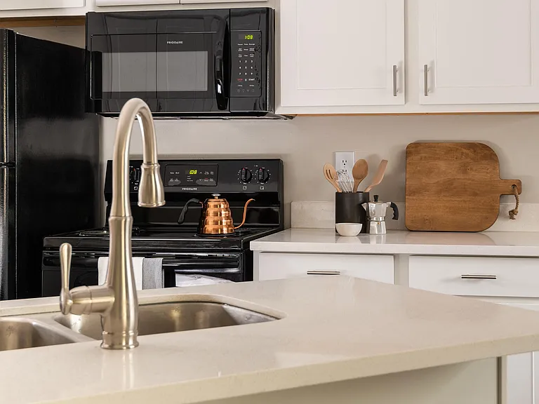 Kitchens with Granite Countertops, Pristine White Natural Wood Cabinets, and Black Appliances