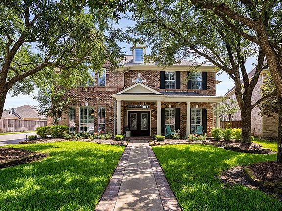 This delightful home is framed with gorgeous established shade trees and is located on a green belt.