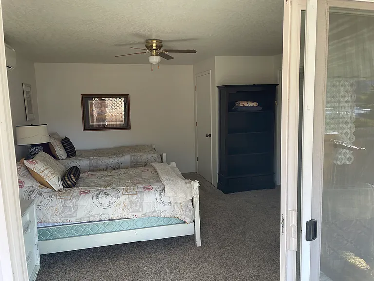 Master bedroom from backyard with large glass slider open.