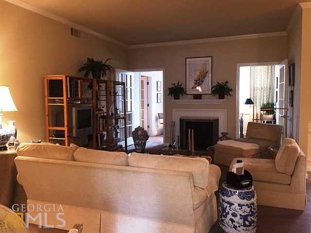 Living room has wood burning fireplace with marble surround.