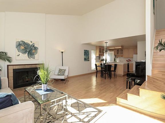 High vaulted ceiling in the Living room gives a great sense of space. Stairs (remodeled photo later) leads up to second floor with two bedrooms and a bathroom. Open Kitchen plan.