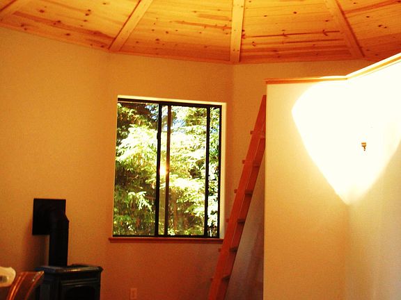 living room, with small loft, and propane hearth with flame window for viewing