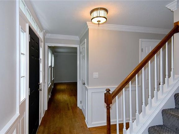 Notice the beautiful dentil crown molding, wainscoting plus hardwood flooring on the entire main level.