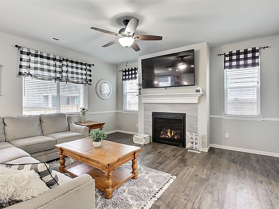 View of your family room, lots of windows and light, great flooring continues and cozy gas fireplace for cooler evenings. >