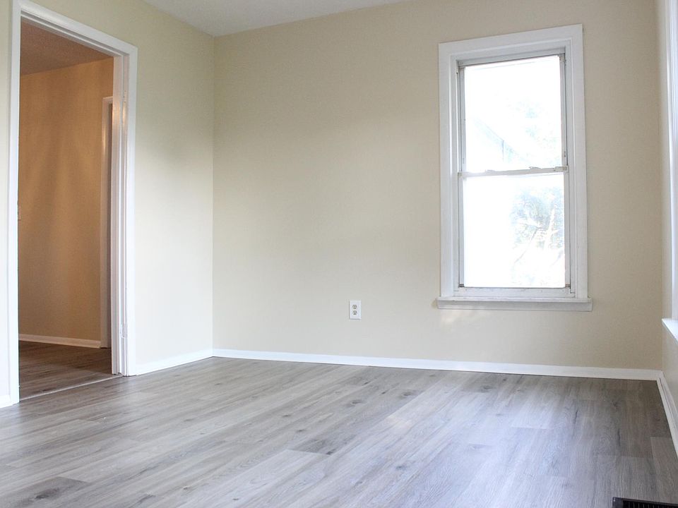 The spacious living room has new luxury vinyl flooring, vinyl windows and a ceiling fan.