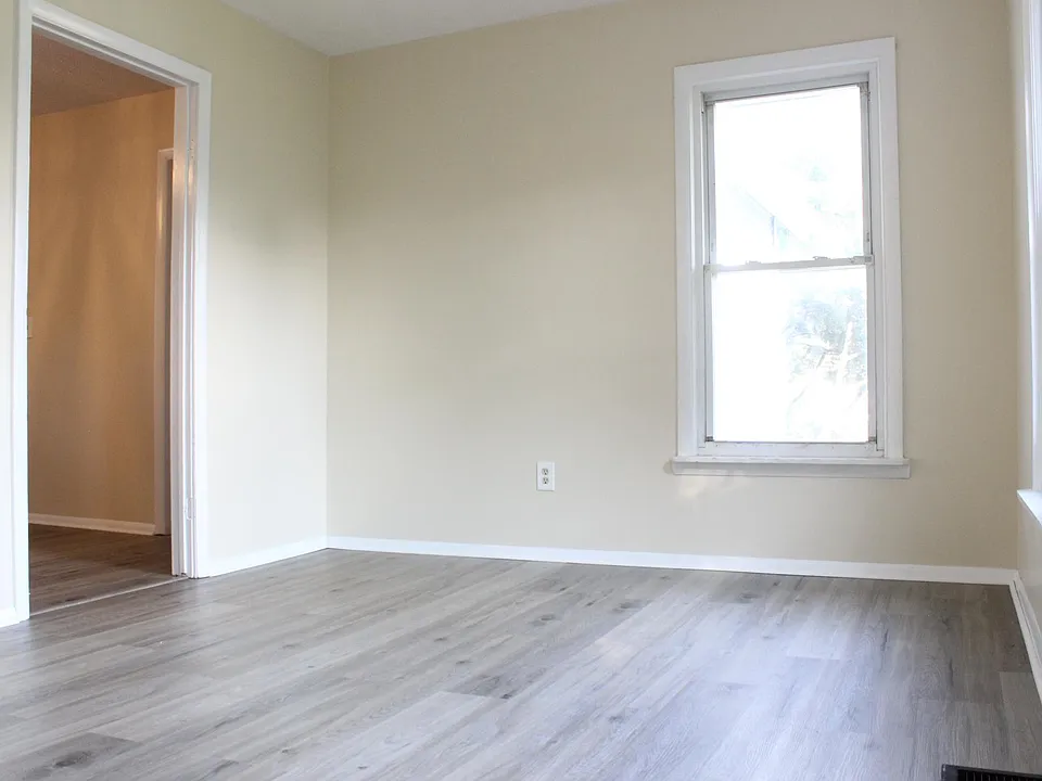 The spacious living room has new luxury vinyl flooring, vinyl windows and a ceiling fan.