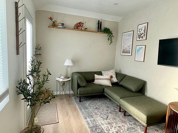 Cozy living room space with a mounted Vizio Smart Tv that telescopes fro the wall and swivels either direction. 
Couch long enough to sleep 1 guest.
Tray table with space for your legs can be used as a workspace or dining tray as you sit on the couch