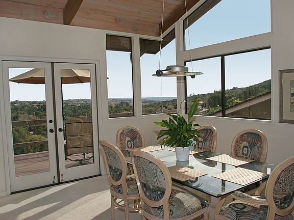 Dining room with French doors & corner windos featuring an ocean view